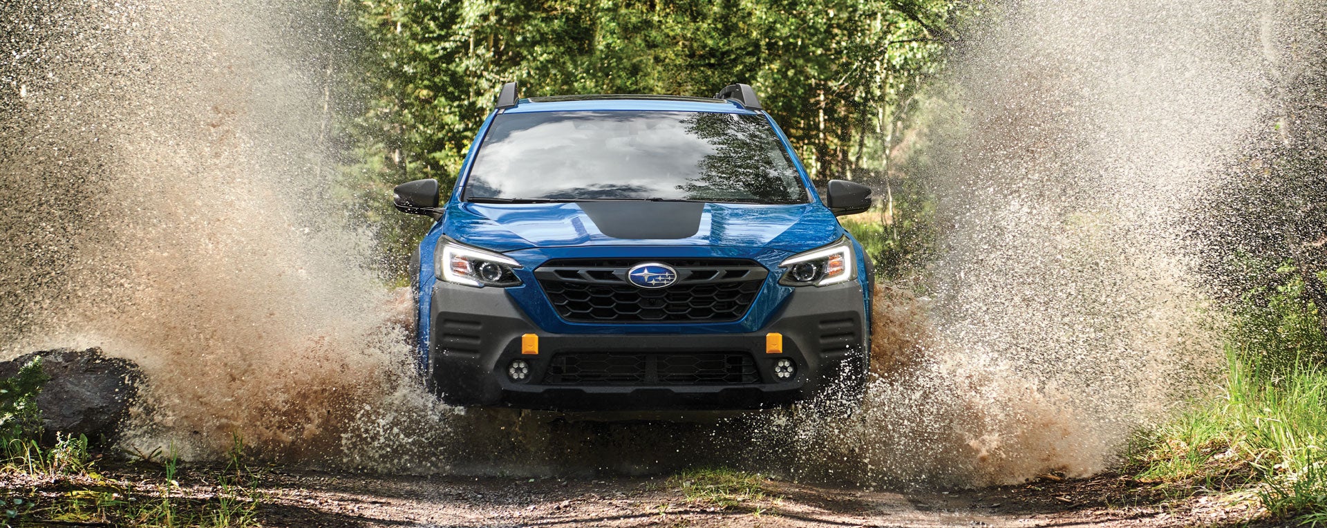 A 2023 Outback Wilderness driving on a muddy trail. | Subaru of Spartanburg in Spartanburg SC