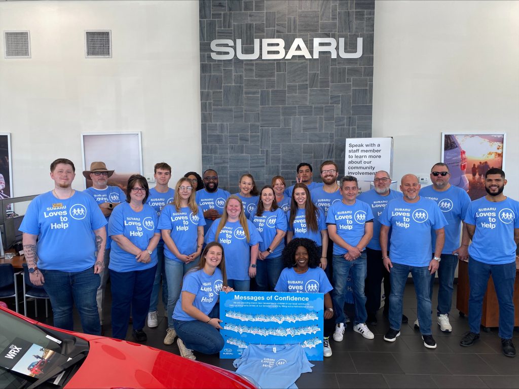 The Subaru of Spartanburg staff poses for a picture wearing their Subaru Loves To Help shirts.