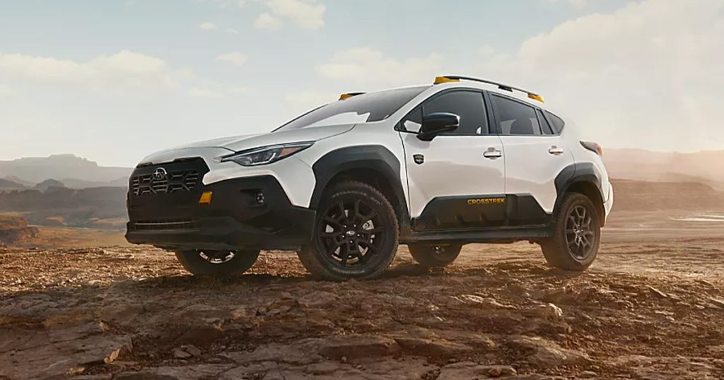 A white 2026 Subaru Crosstrek sits parked off-road amongst a rocky road.