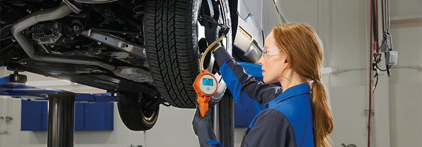 A Subaru technician checking tire pressure. | Subaru of Spartanburg in Spartanburg SC