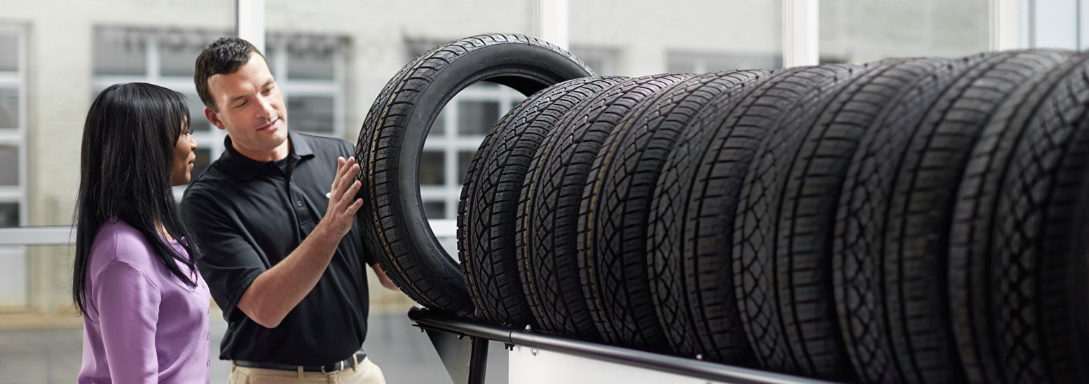 Subaru service representative showing customer a tire. | Subaru of Spartanburg in Spartanburg SC