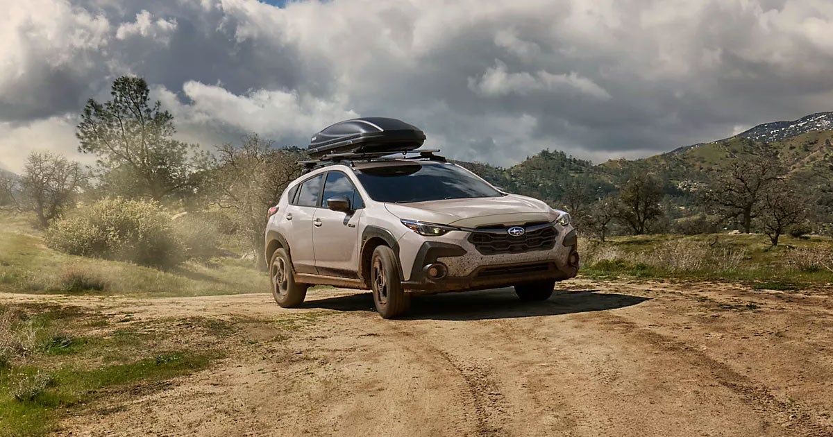 A Subaru Crosstrek drives down a dirt road